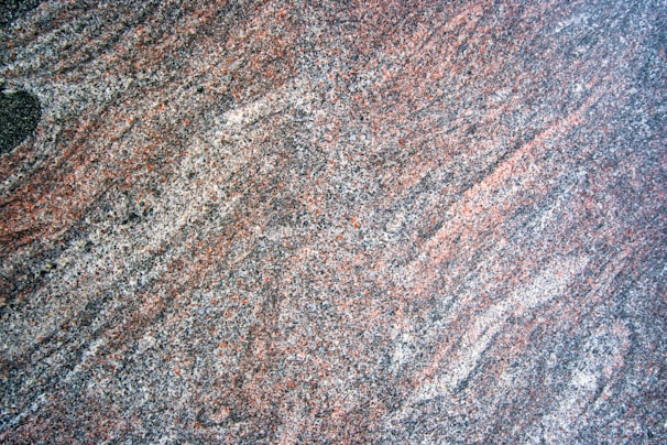 a close up of a granite surface with a black object in the middle