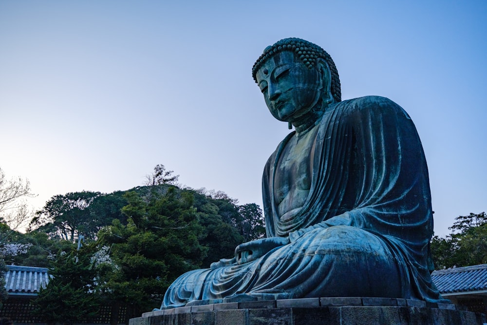a large buddha statue sitting in a park