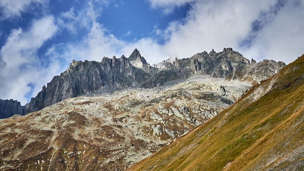 a mountain range with a few clouds in the sky