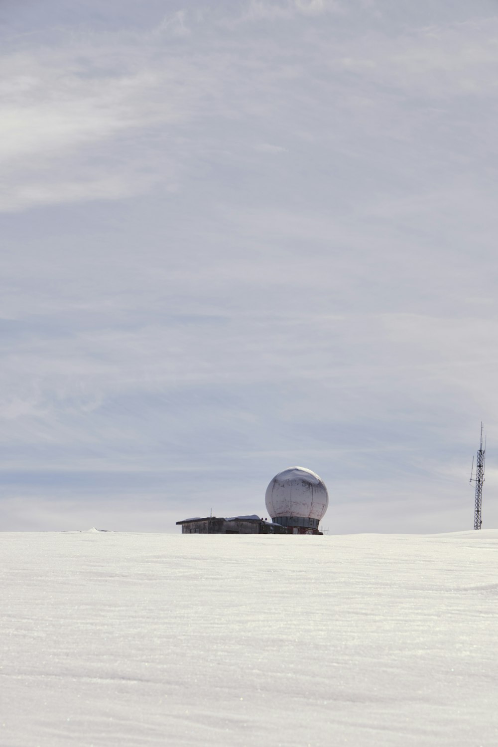 a satellite dish sitting on top of a snow covered field