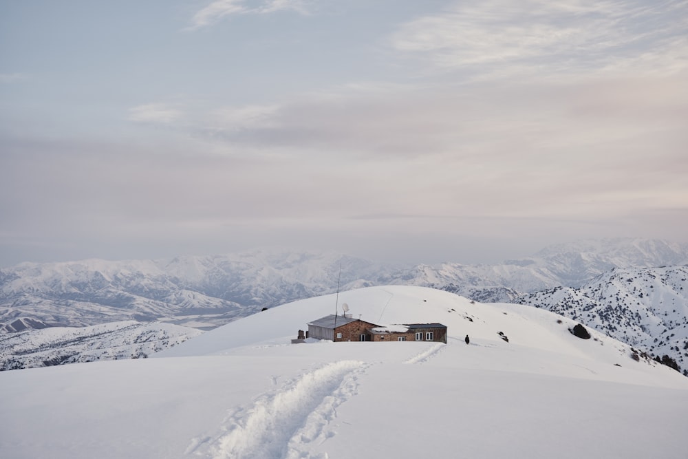 a snow covered mountain with a house on top of it