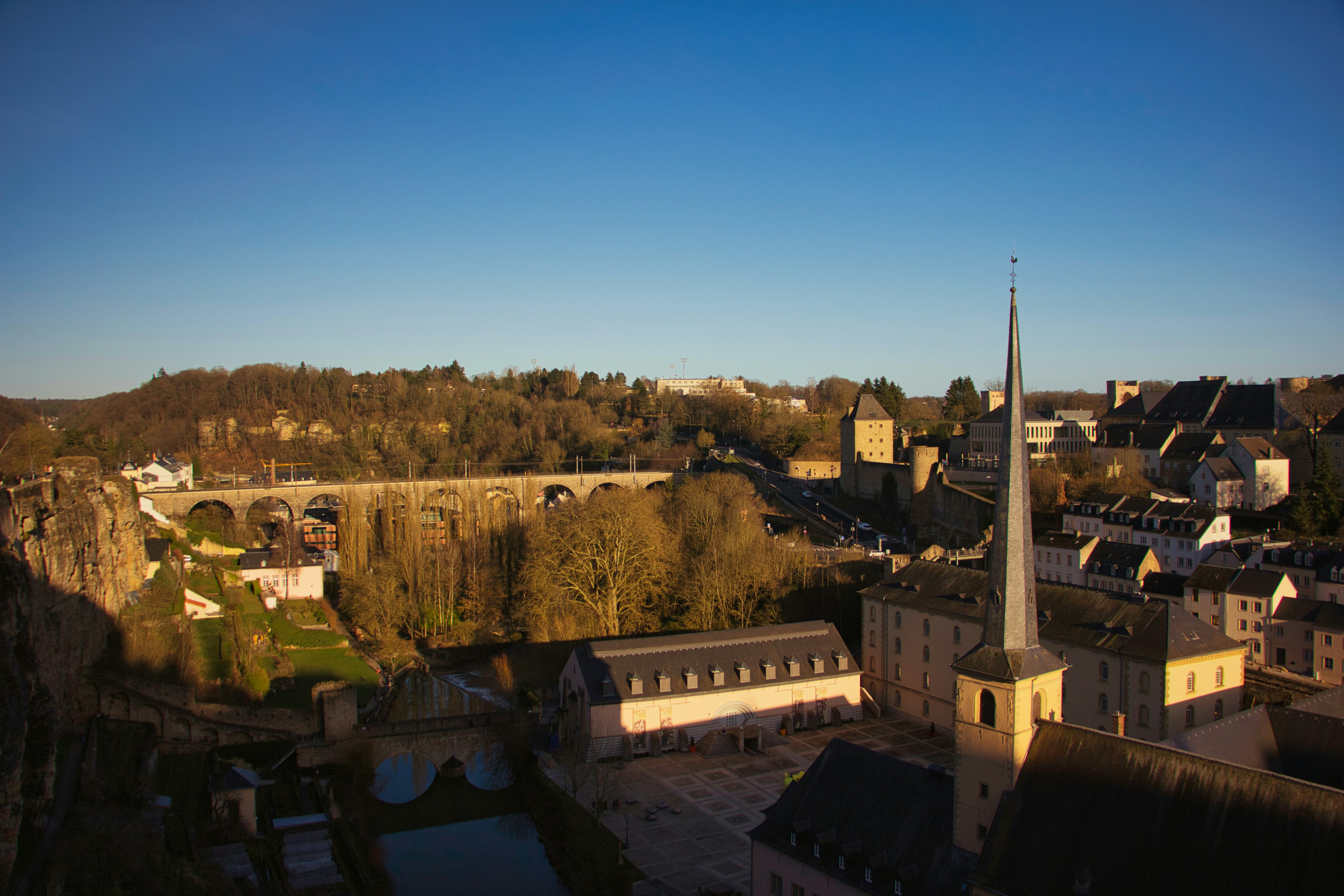 an aerial view of a city with a bridge in the background