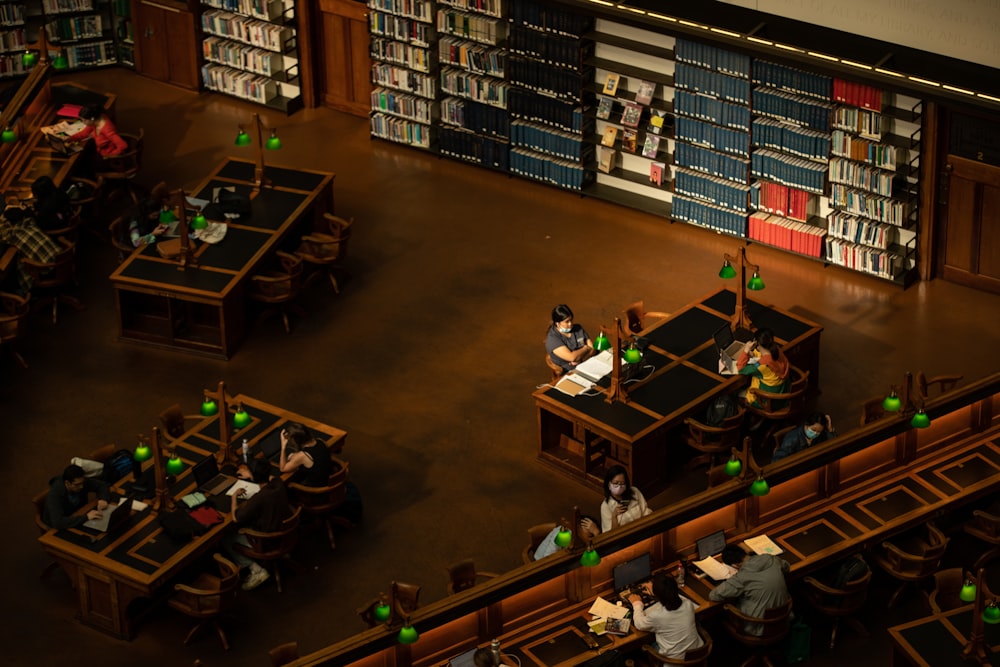 um grupo de pessoas sentadas em mesas em uma biblioteca