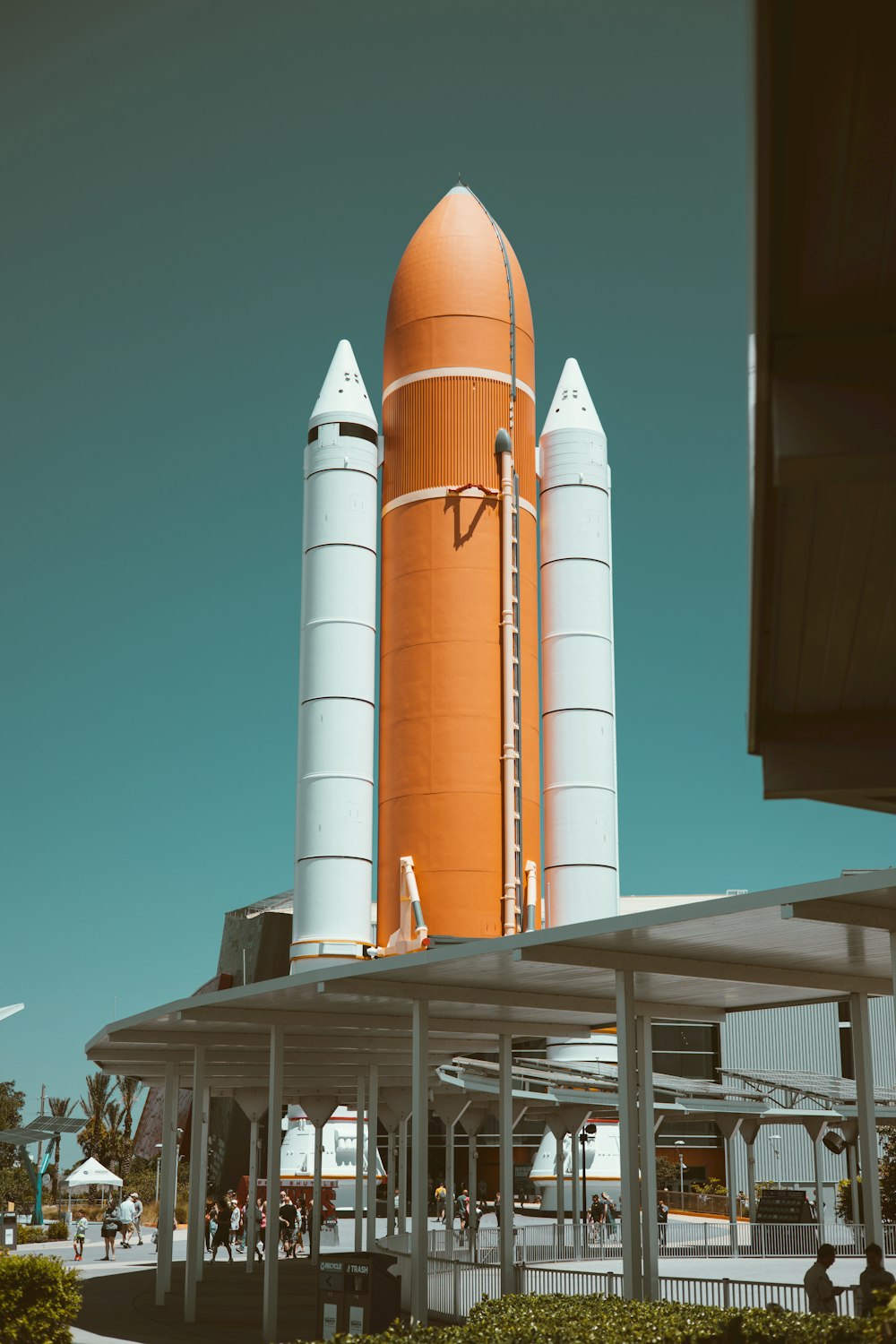 Une grande fusée orange assise au sommet d’un bâtiment