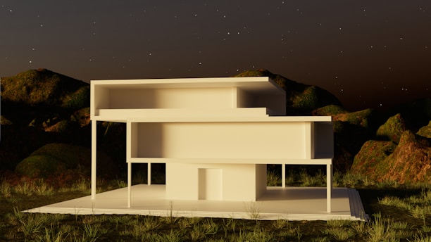 a white building sitting on top of a lush green field