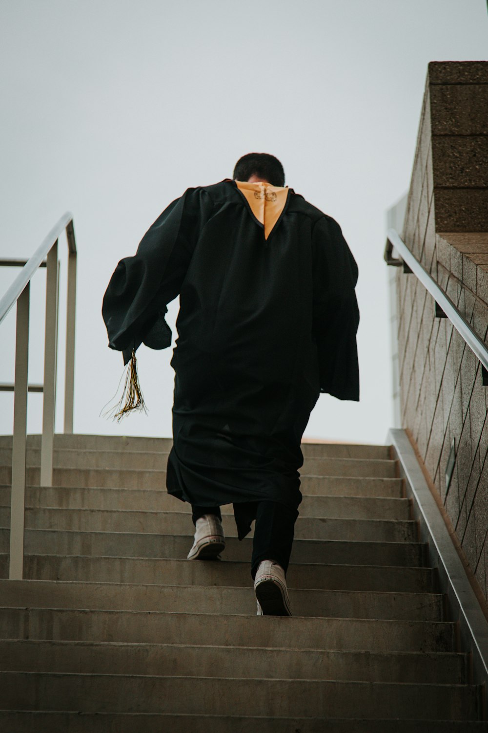 um homem em um manto andando por um lance de escadas