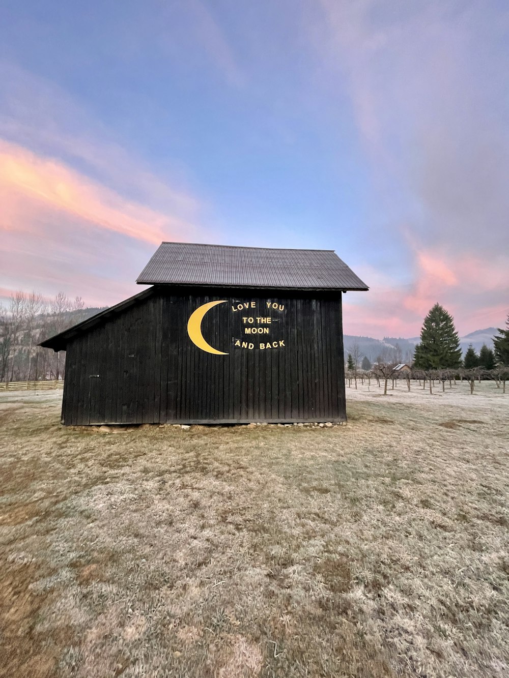 a black barn with a yellow crescent on it
