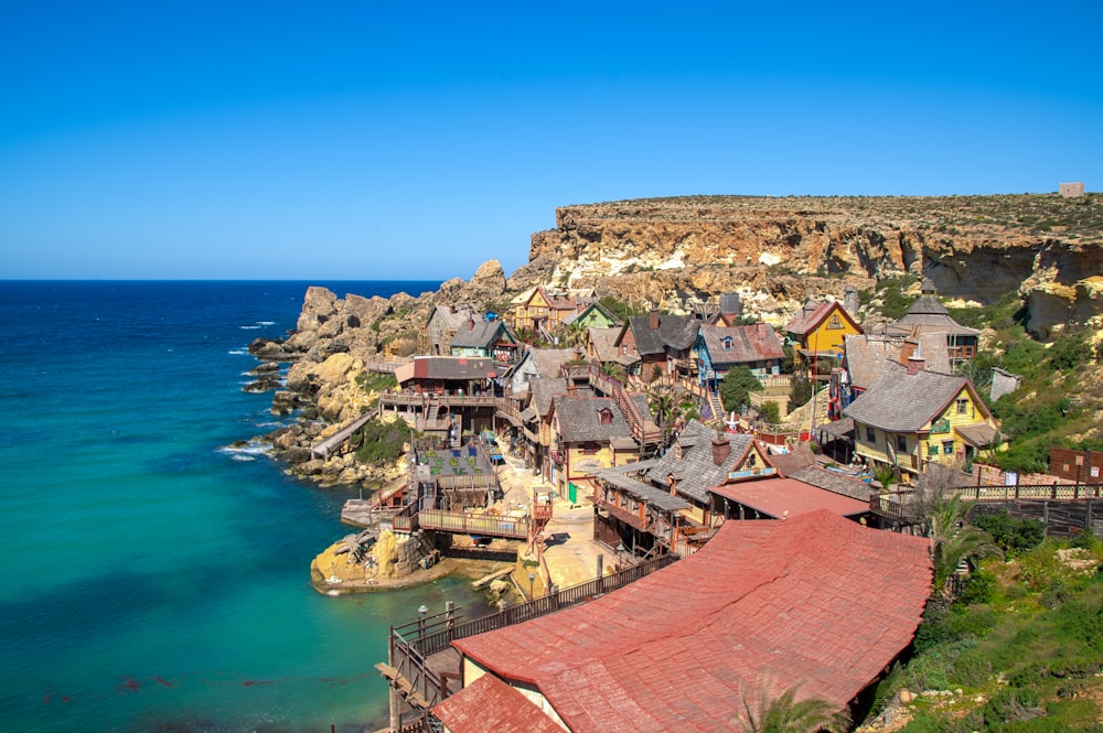 a village on the edge of a cliff next to the ocean