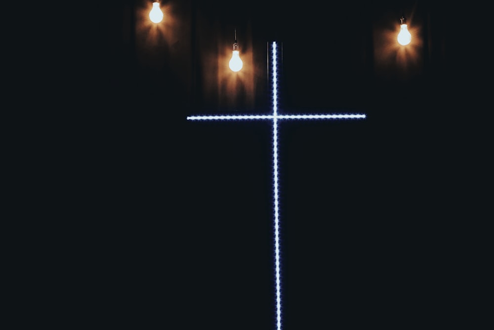 a cross is lit up in the dark