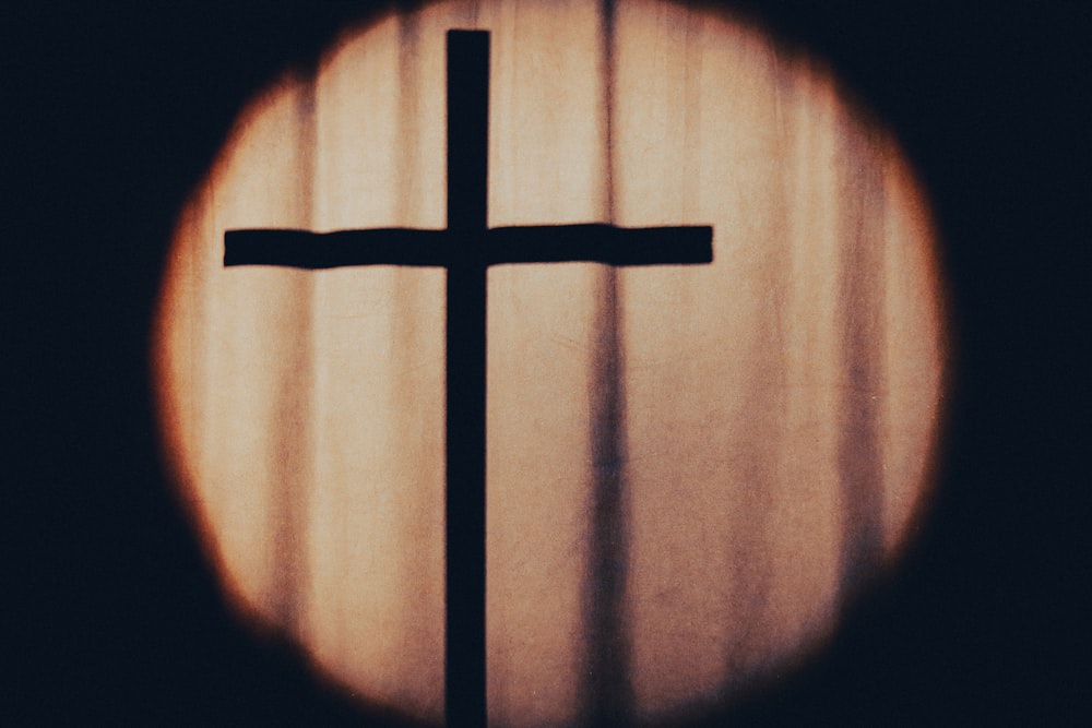 a cross is seen through a circular window
