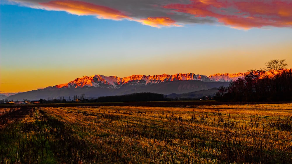 a sunset view of a mountain range in the distance