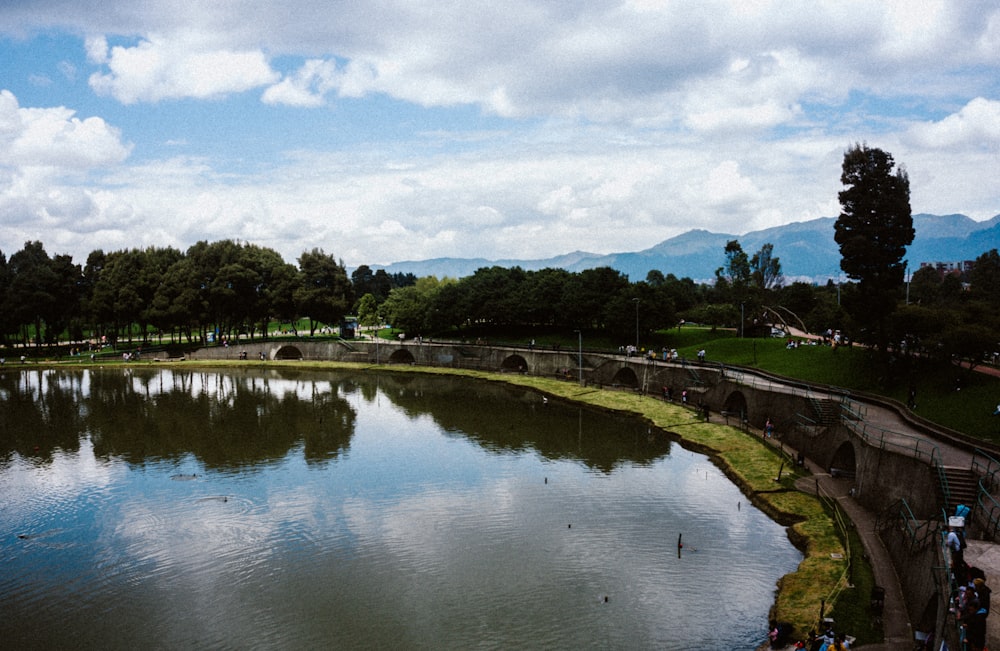 a lake surrounded by trees and a bridge