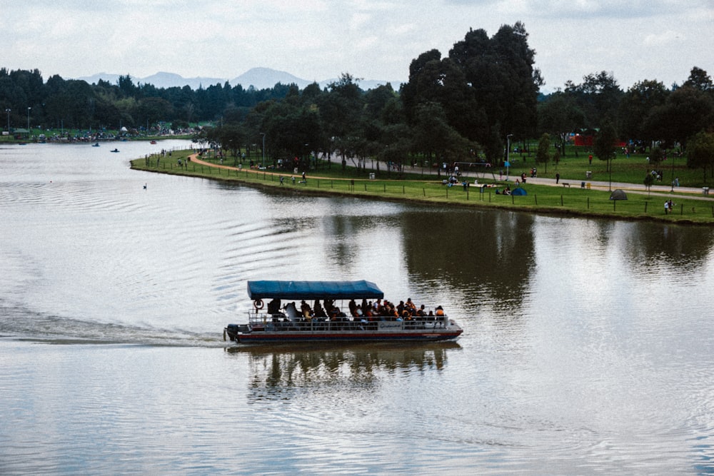 a boat filled with people riding on top of a lake