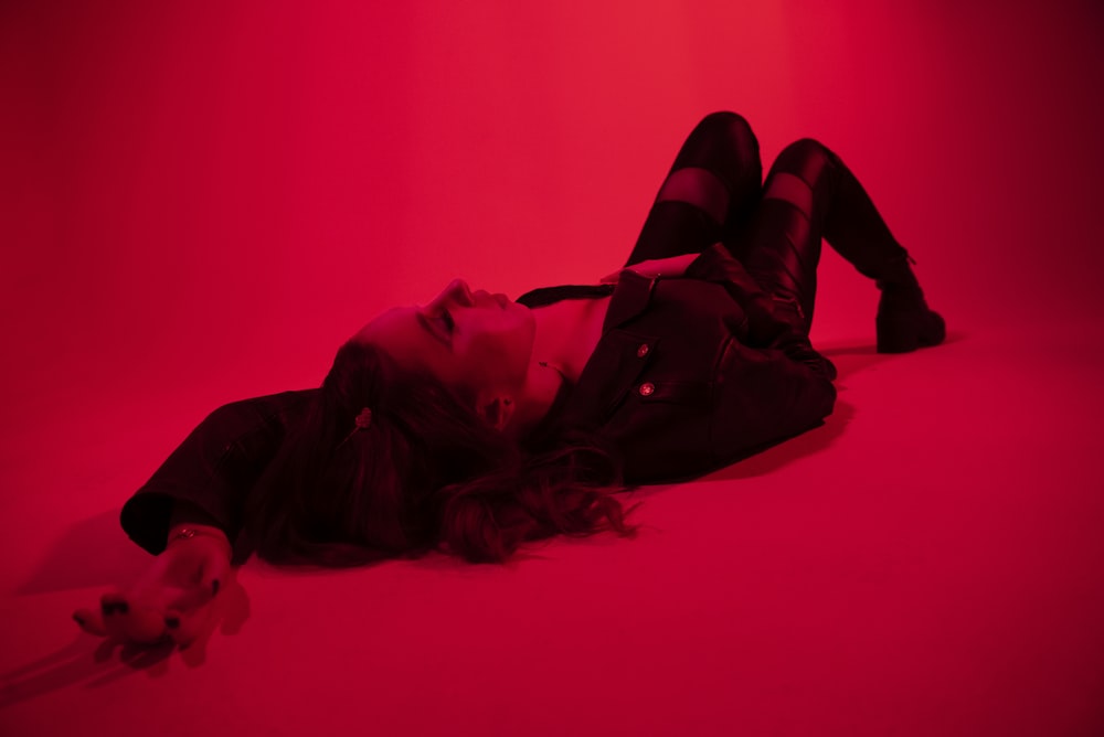 a woman laying on the floor in a dark room