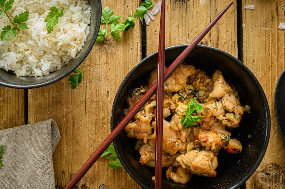 a bowl of food with chopsticks next to it