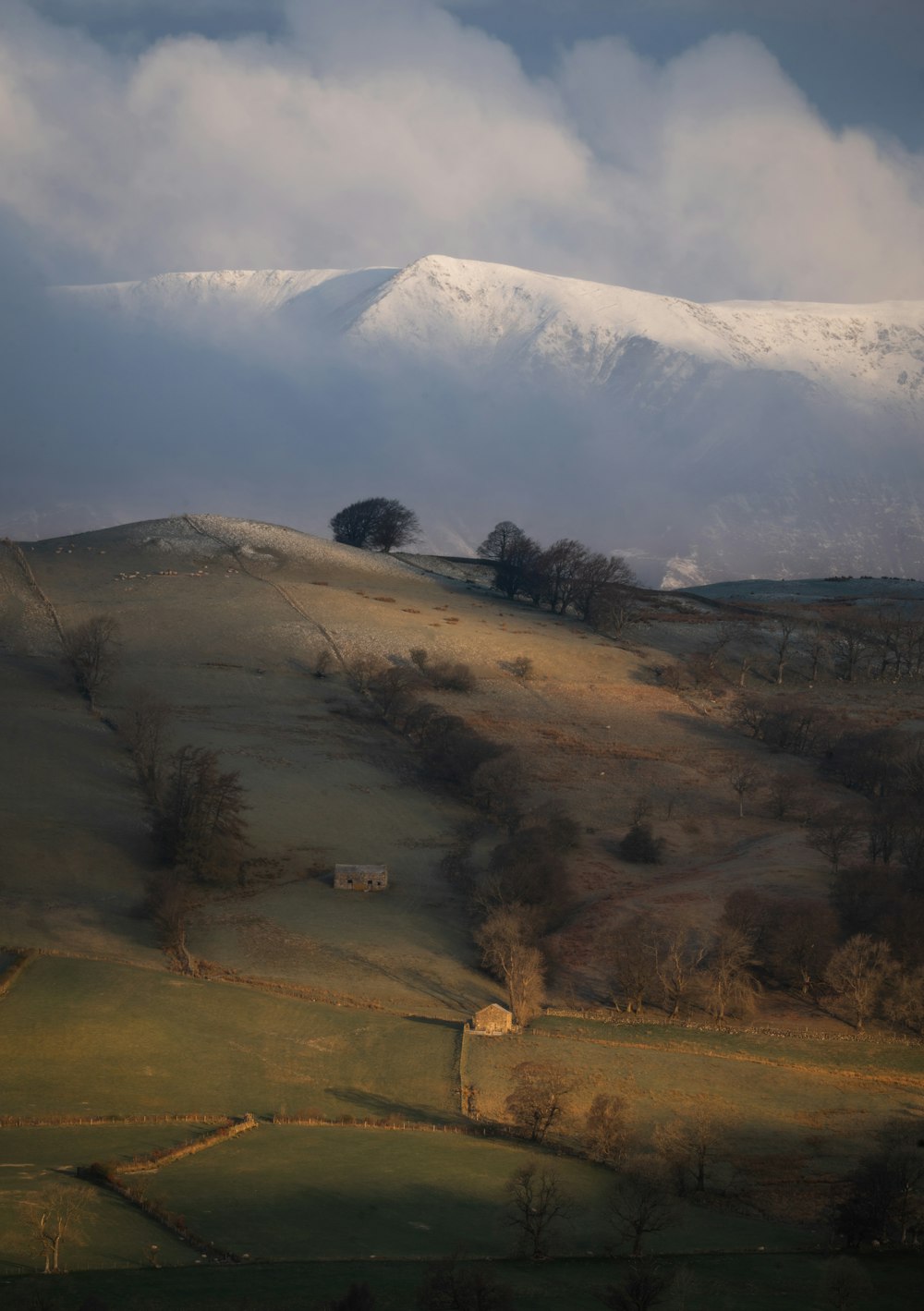 a snow covered mountain with a small house in the foreground