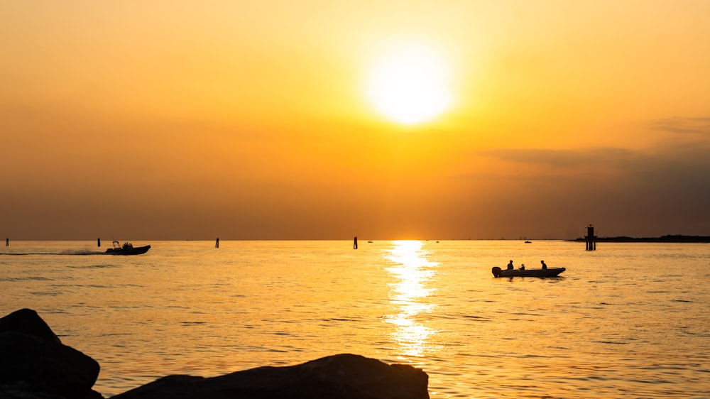 a couple of boats floating on top of a body of water