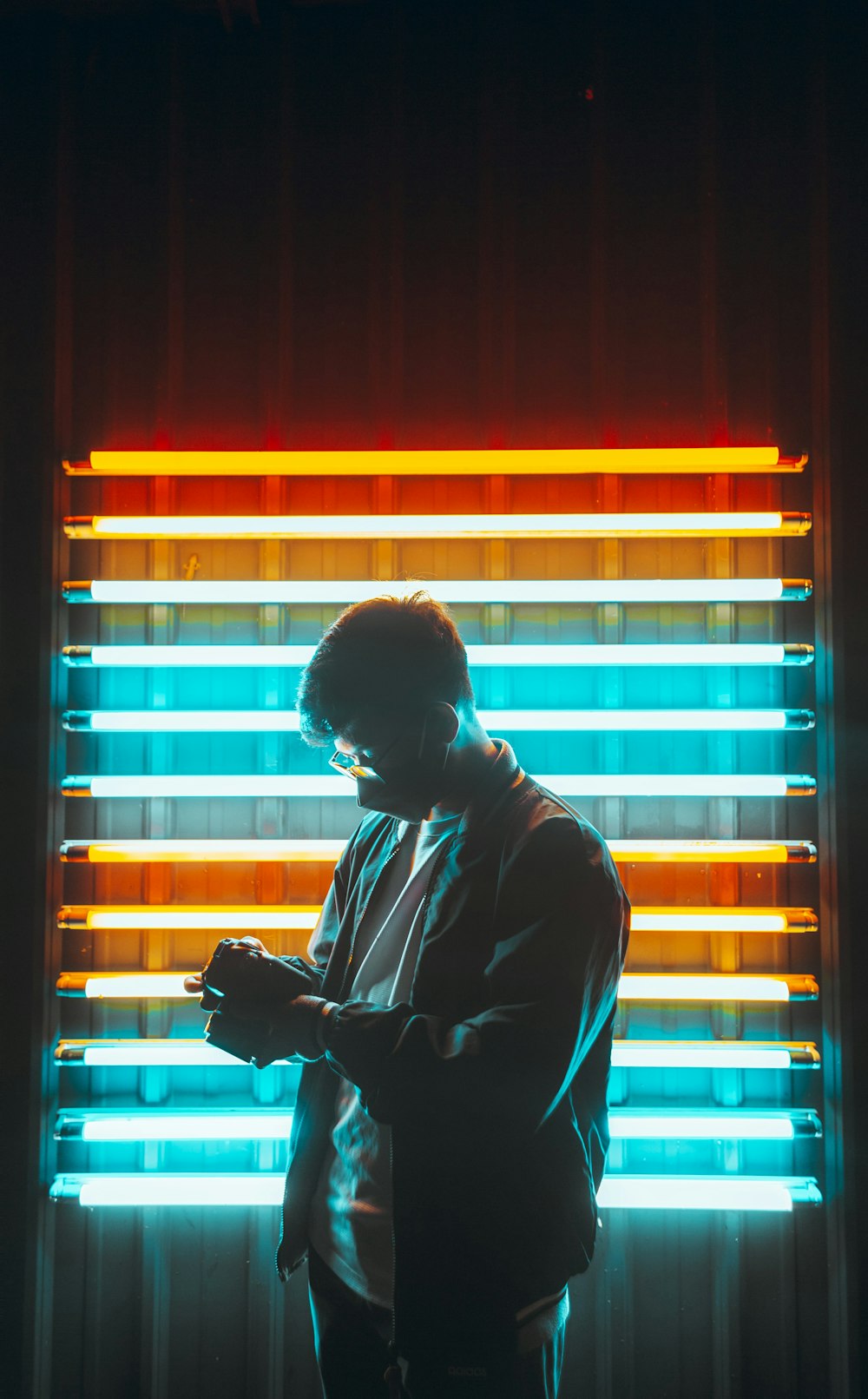 a man standing in front of a window using a cell phone