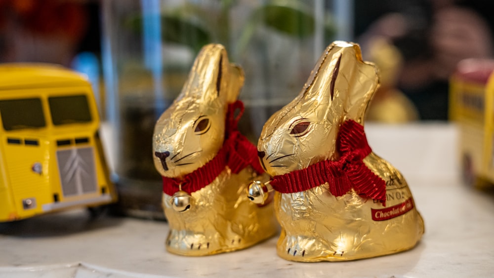 a couple of gold rabbits sitting on top of a table