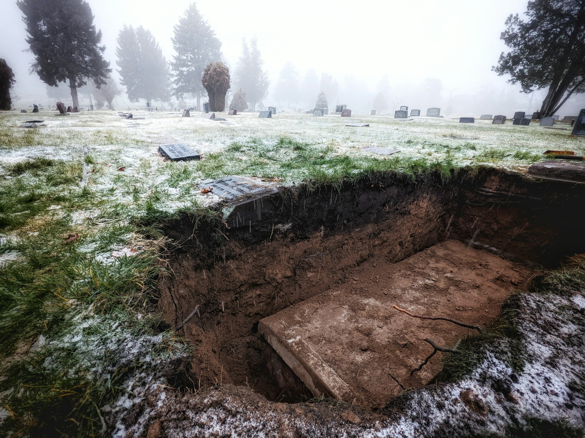 a grave in the middle of a field covered in snow