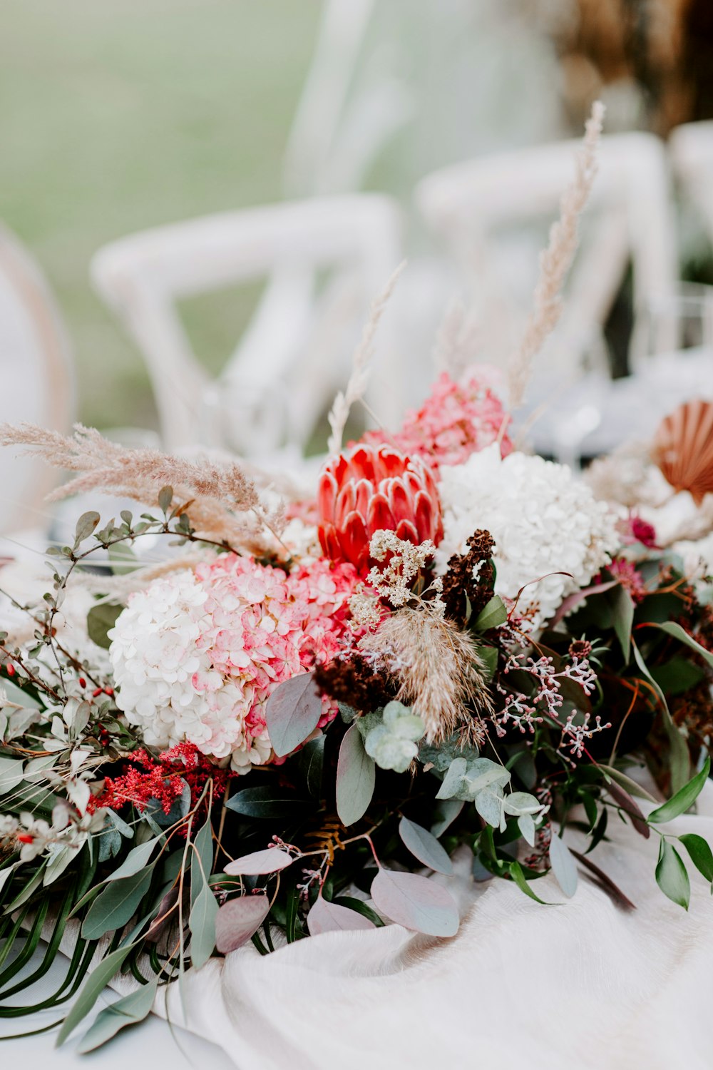 a bouquet of flowers and greenery on a table