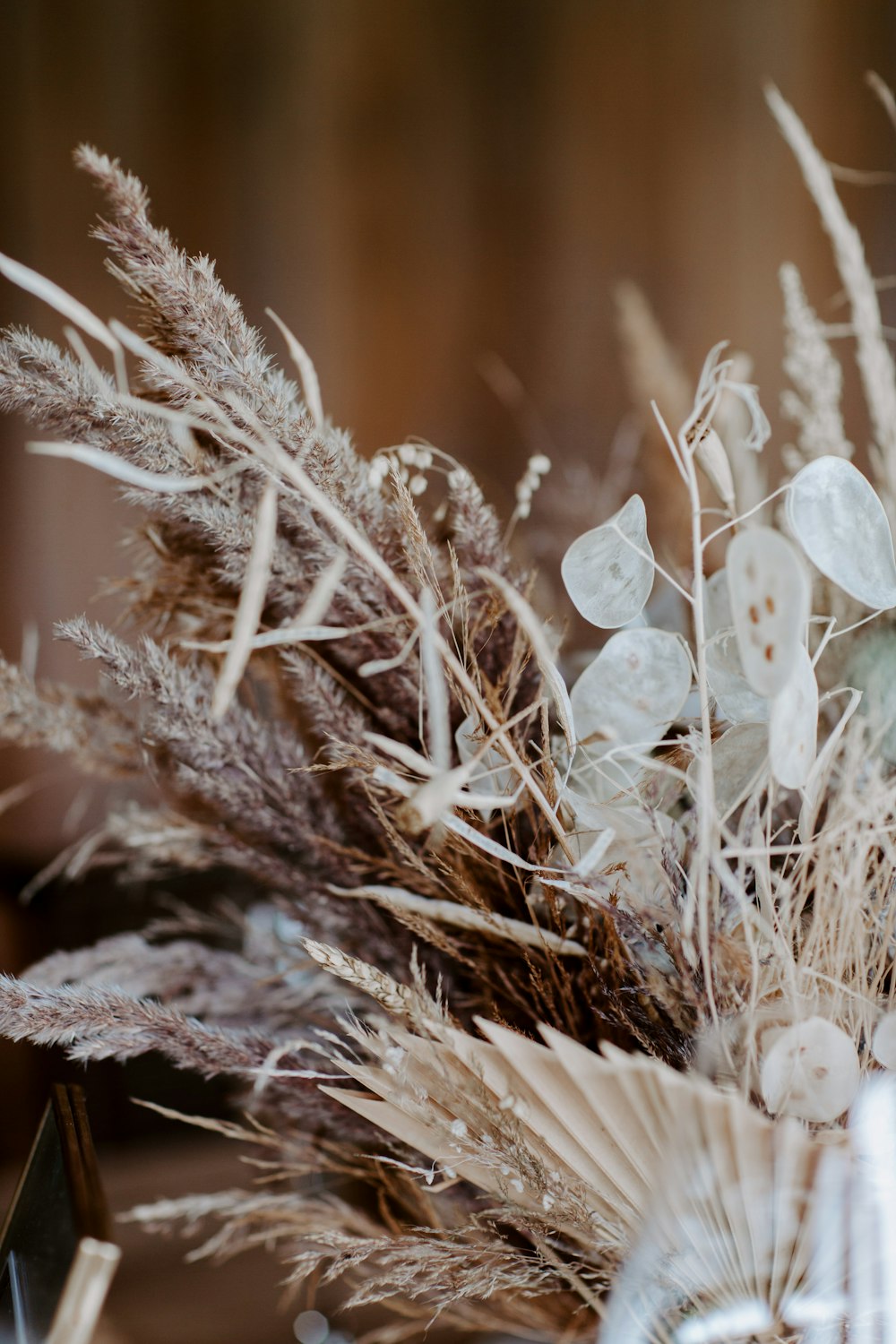 a vase filled with lots of dried flowers