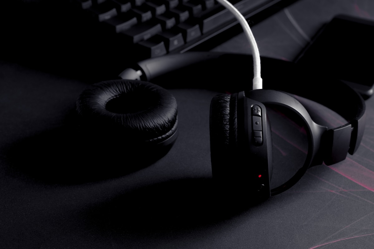 A pair of headphones sitting next to a keyboard