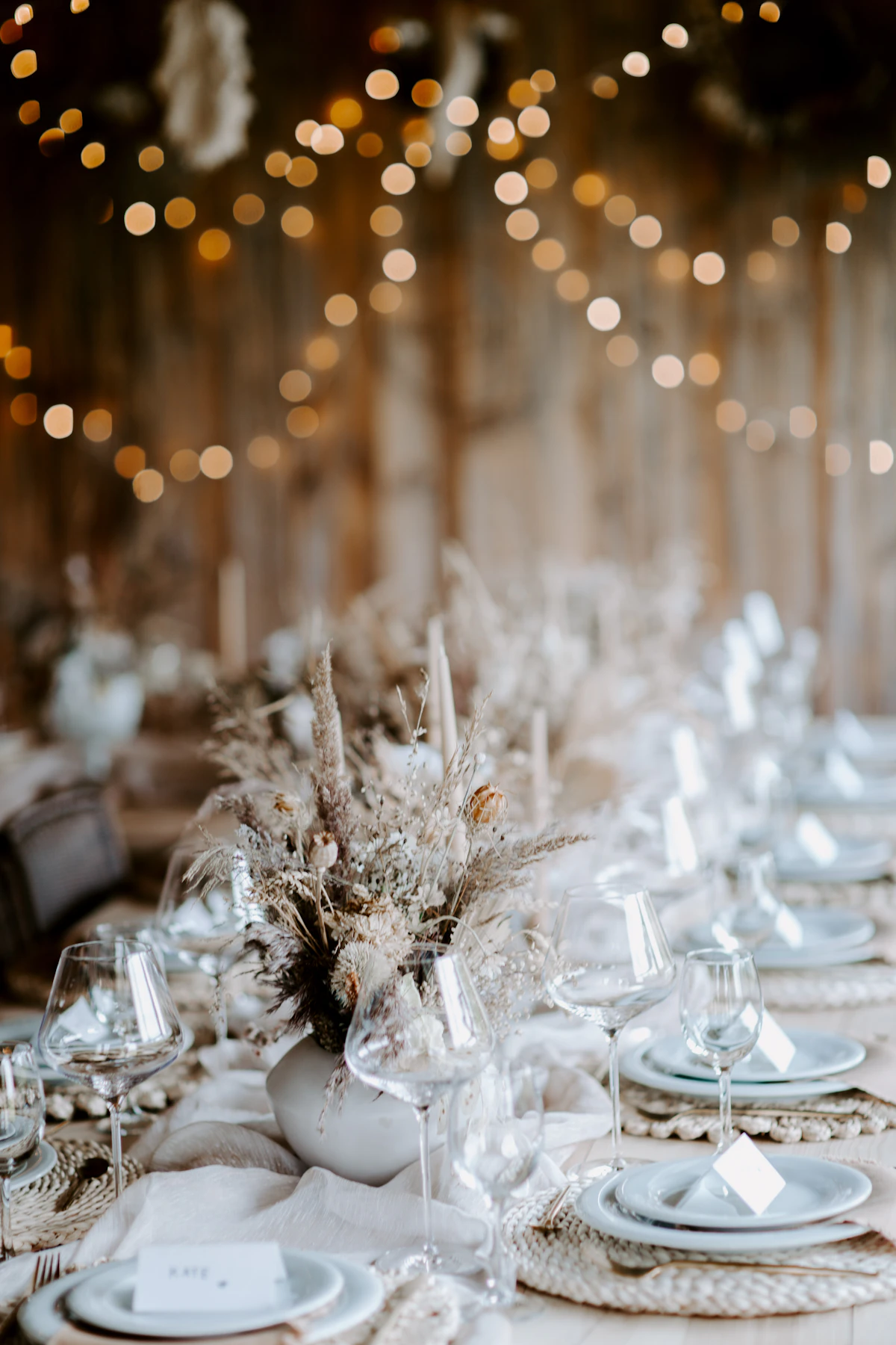 Reception table set with white plates and cutlery for a wedding dinner