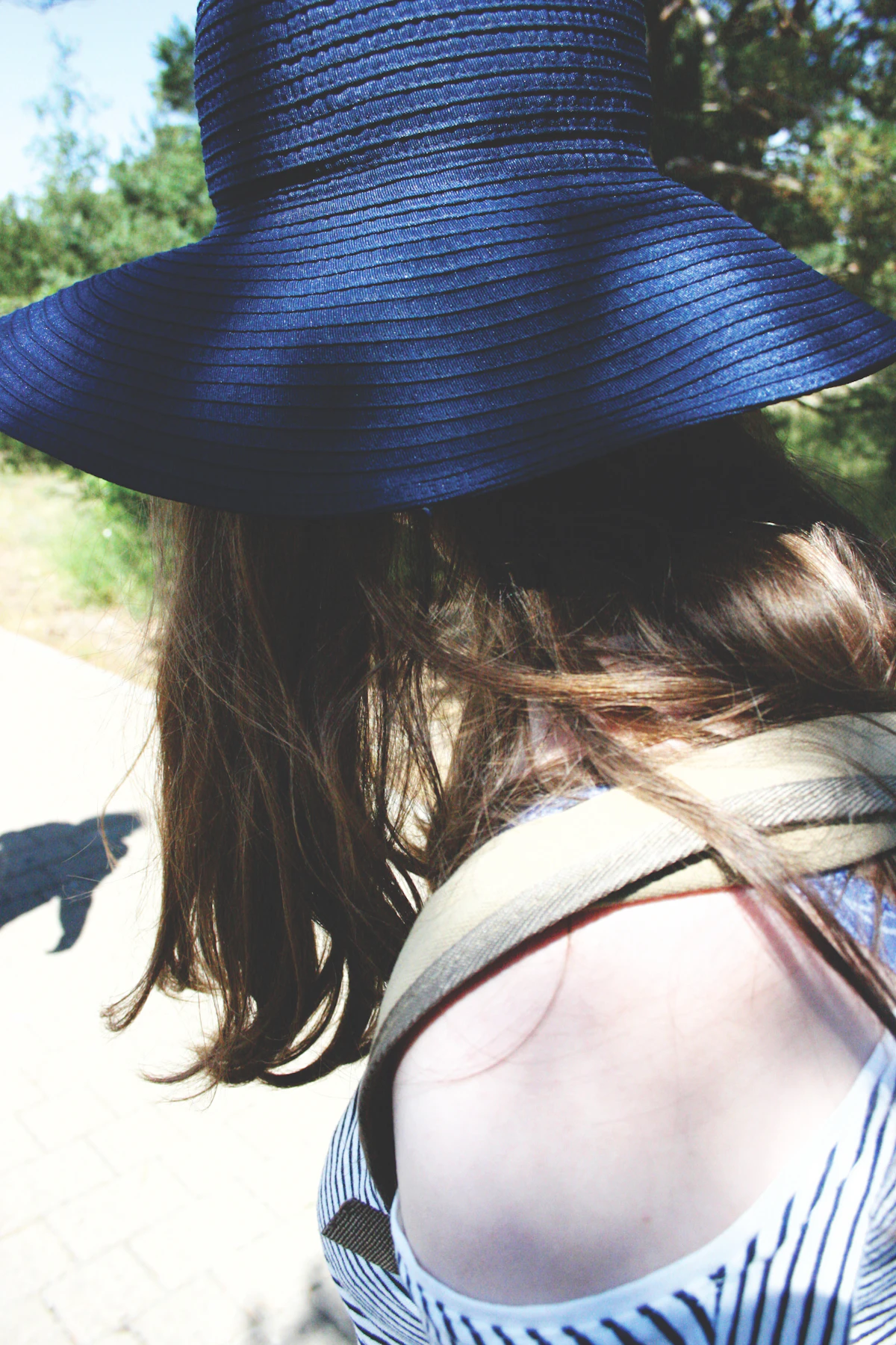 Trottoir au soleil, chapeau bleu