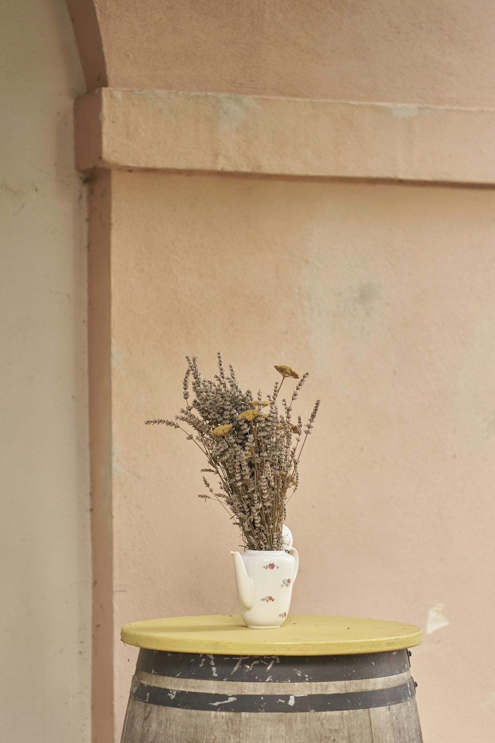 a vase sitting on top of a wooden barrel