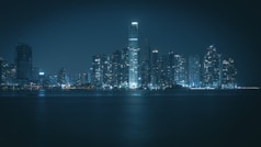 a city skyline at night with a body of water in the foreground