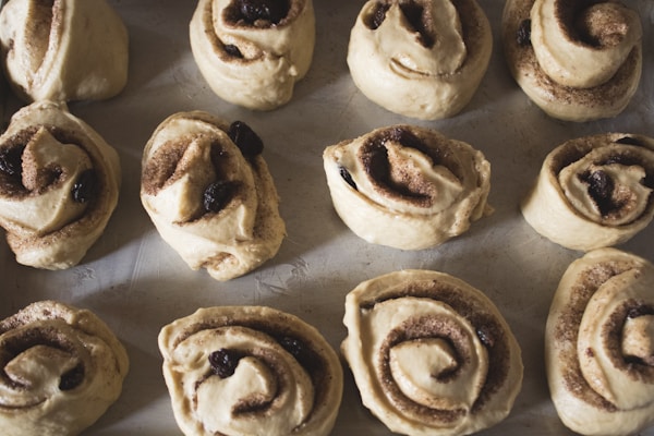 A baking sheet filled with cinnamon rolls on top of a table