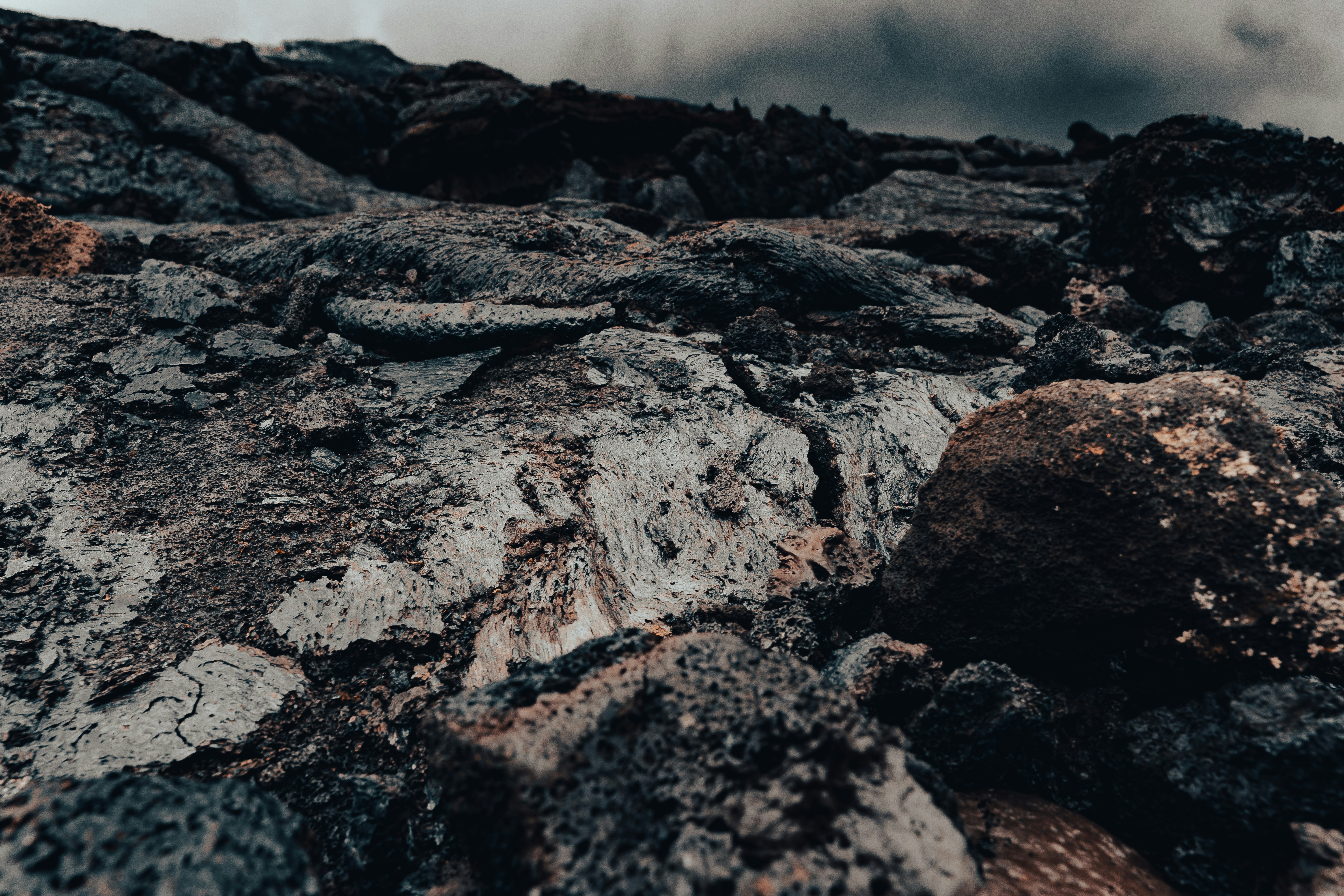 a rocky area with rocks and dirt under a cloudy sky, Lava "artefacts" of Fagradalsfjall volcano, Iceland,  photographed from close distance