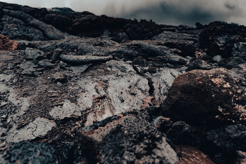 a rocky area with rocks and dirt under a cloudy sky