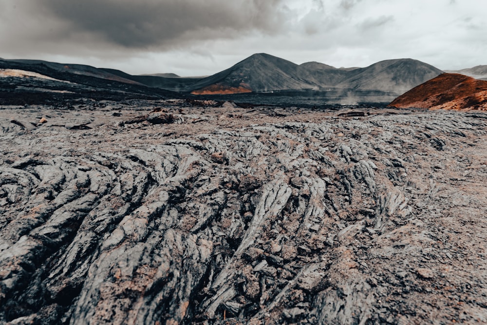 a dirt field with mountains in the background