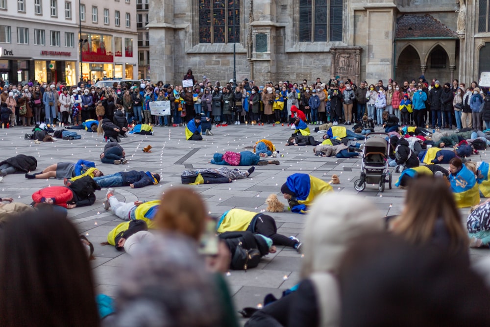 a crowd of people standing around a group of people laying on the ground