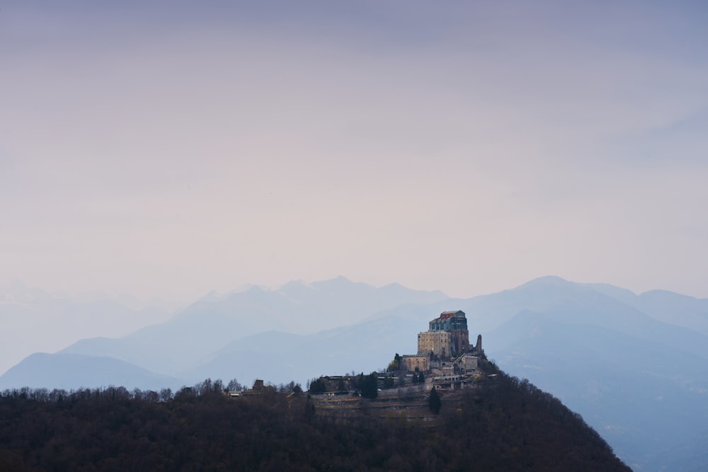 a castle on top of a hill with mountains in the background