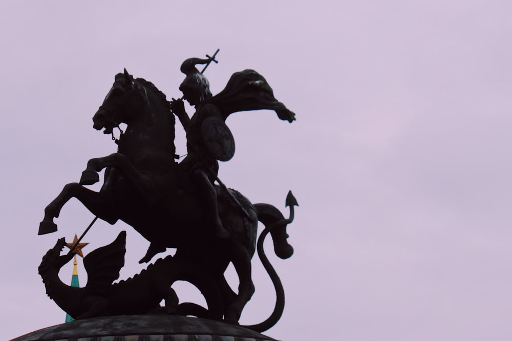 a statue of a man on a horse on top of a building