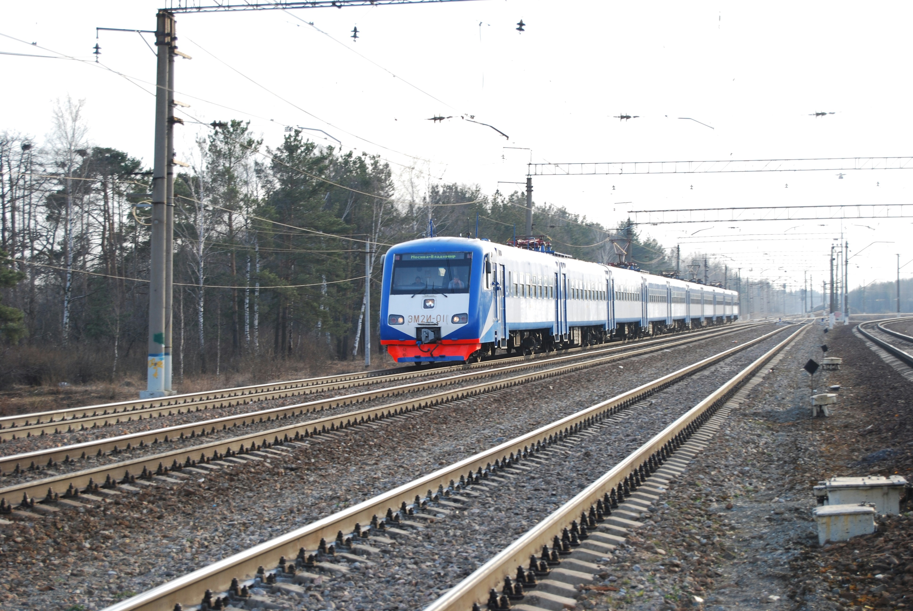 a blue and white train traveling down train tracks