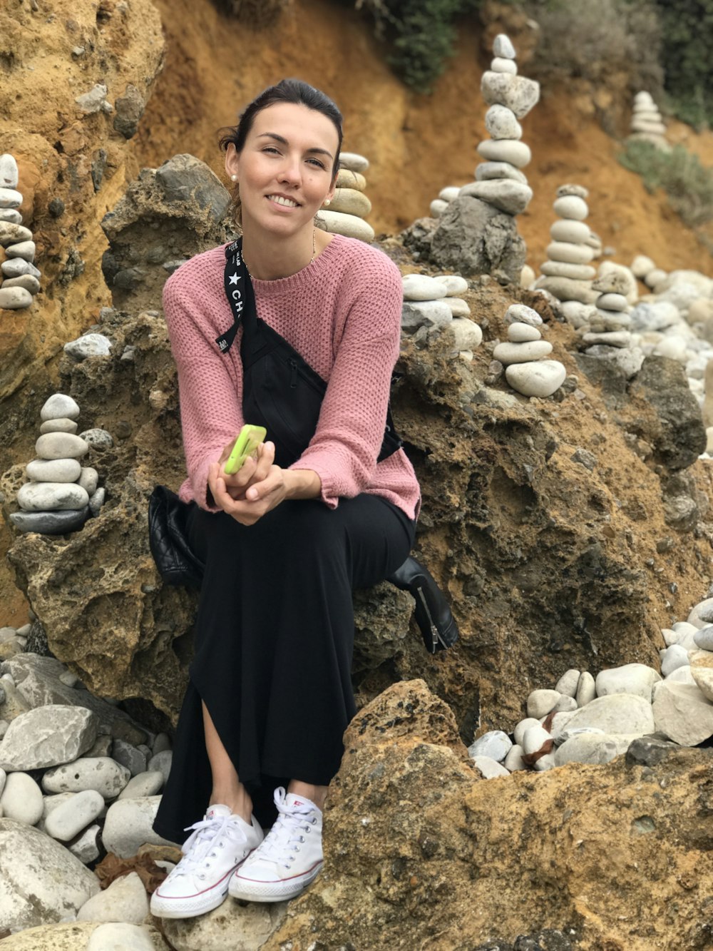 a woman is sitting on a rock pile