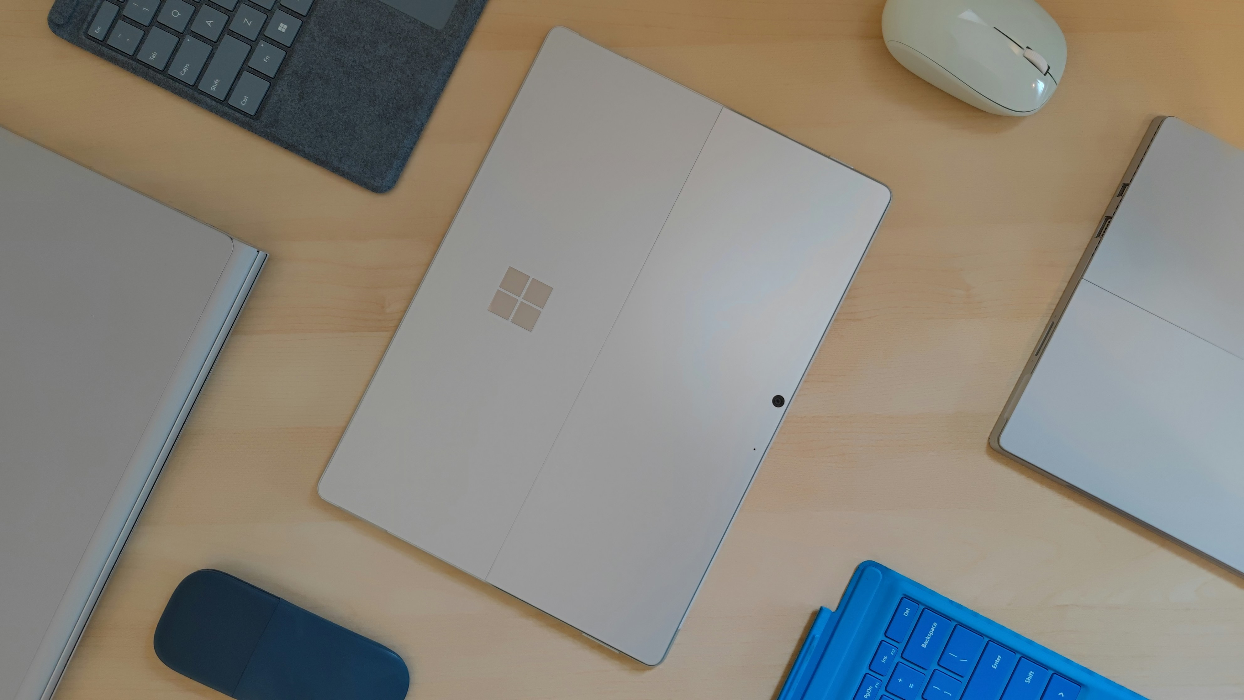a desk with a keyboard, mouse, and other items on it