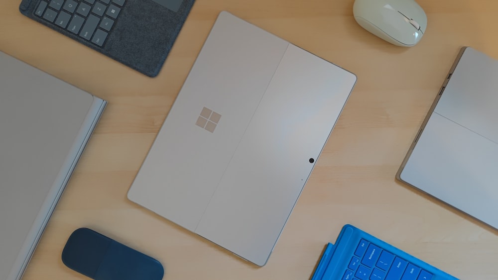 a desk with a keyboard, mouse, and other items on it