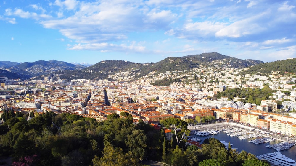 an aerial view of a city with a harbor and mountains in the background