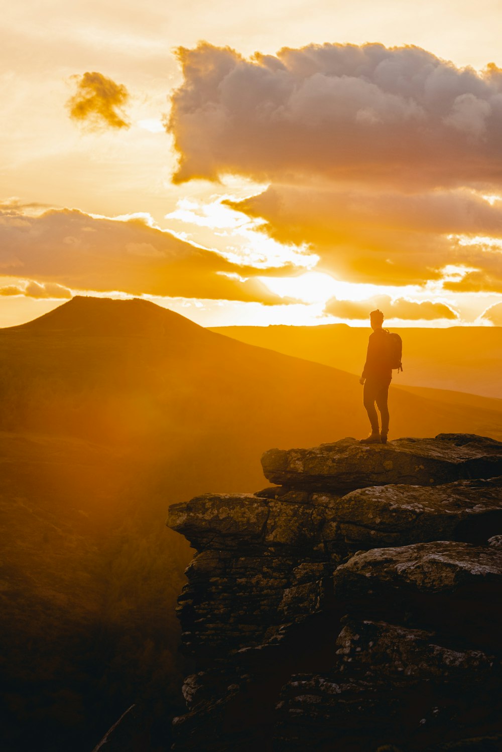 Eine Person, die bei Sonnenuntergang auf einem Berg steht