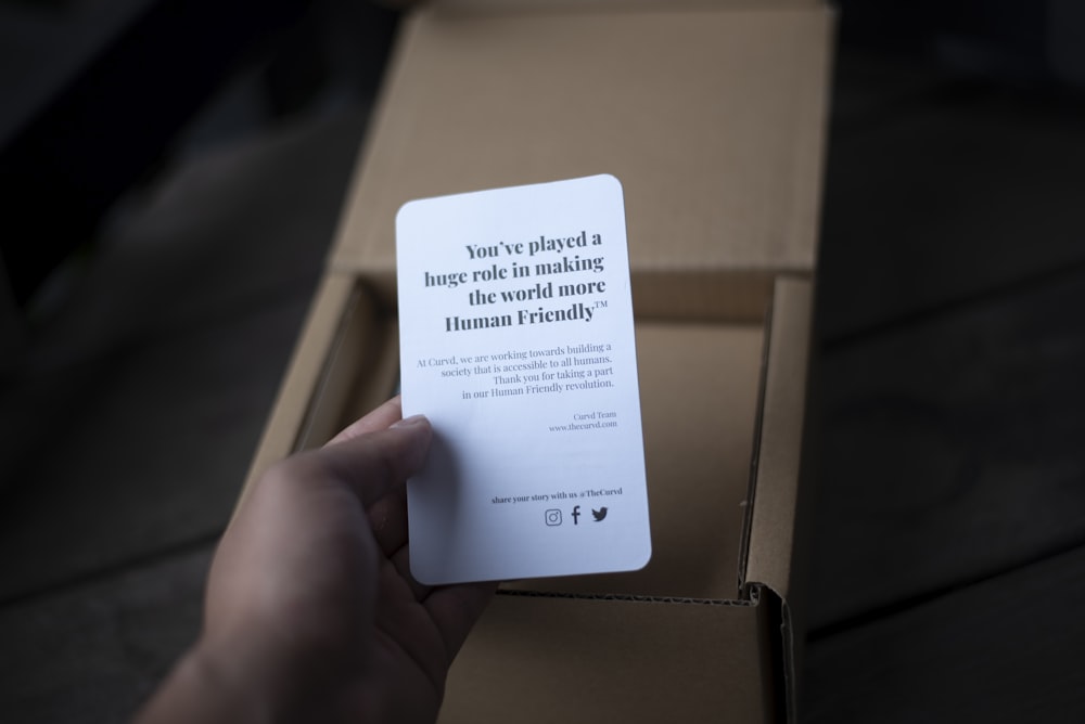 a person is holding a card in a box