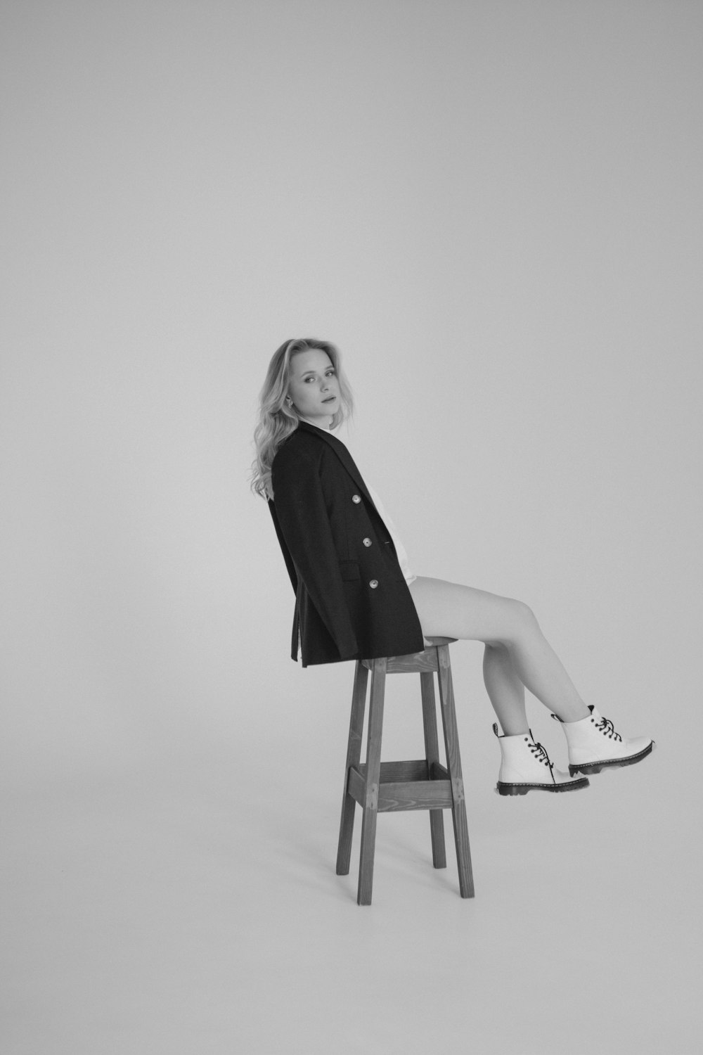 a woman sitting on top of a wooden stool