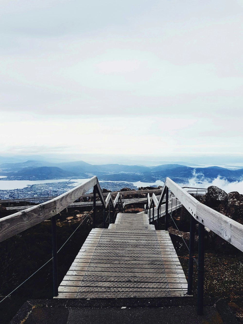 a wooden walkway leading to the top of a mountain