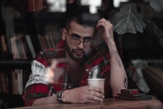 A thoughtful person sitting at a desk with papers and a cup of coffee, reflecting on a decision.