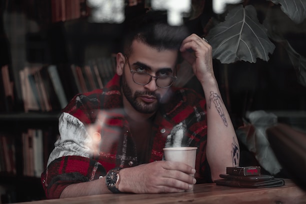 A thoughtful person sitting at a desk with papers and a cup of coffee, reflecting on a decision.
