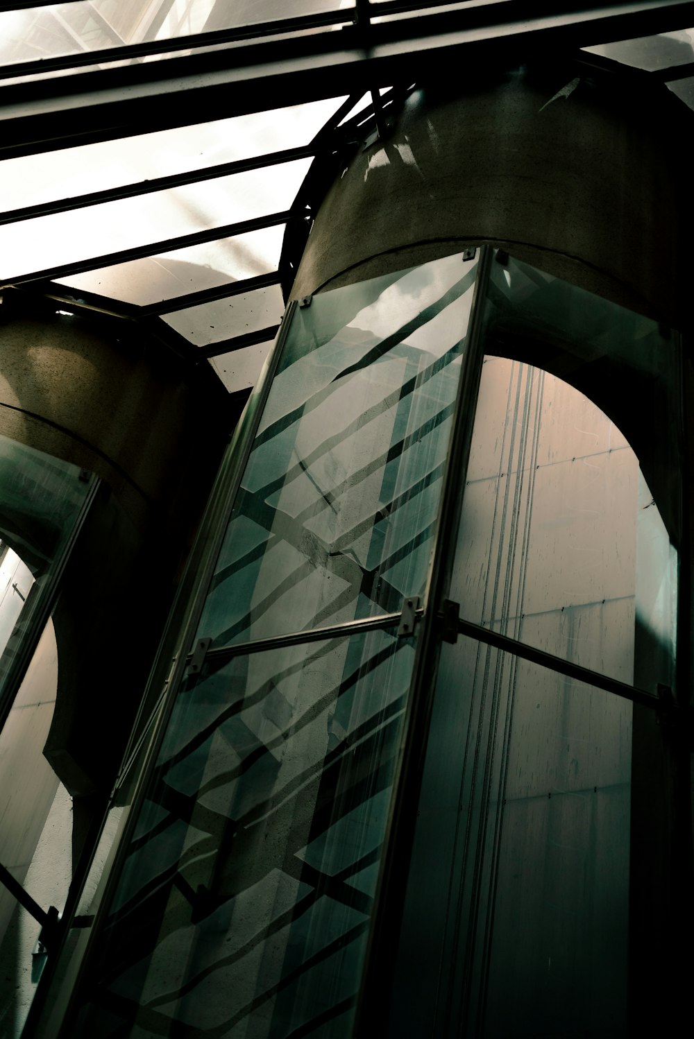 a tall glass building with a clock on it's side